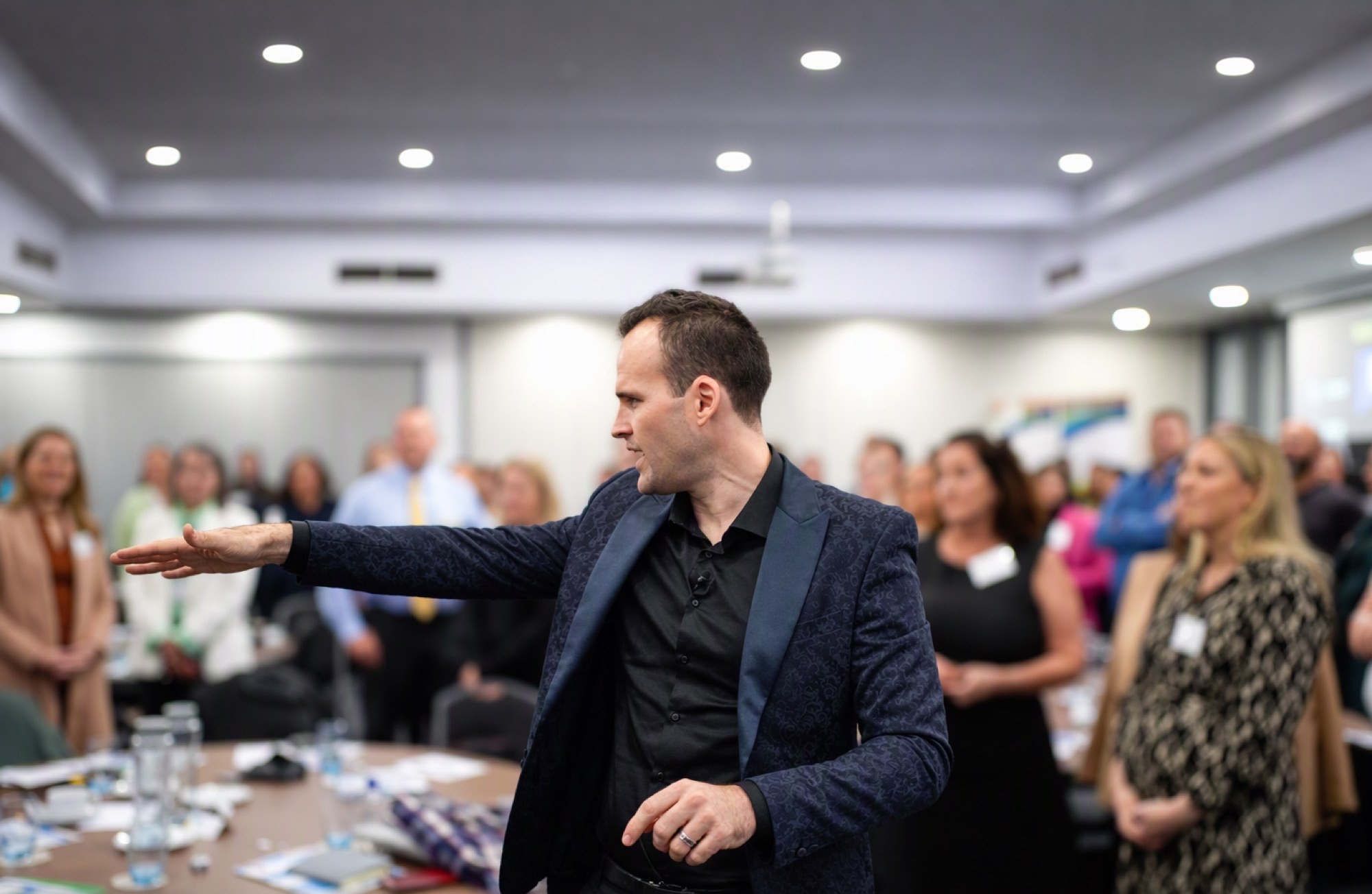 Andrew Ramsden working the room with a standing audience at a conference